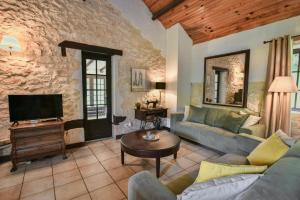 a living room with a couch and a tv at Font Neuve in Souillac
