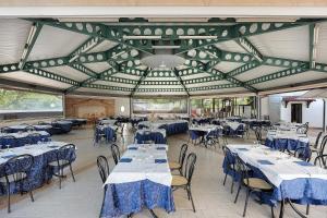 a dining room with tables and chairs with blue linen at Marina Living Rooms and Pool in Paestum