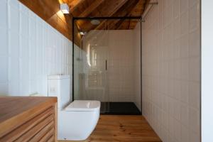 a bathroom with a toilet and a glass shower at Feel Discovery Casa da Aldeia in Mós