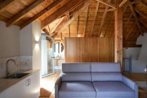 a living room with a couch and a kitchen at Feel Discovery Casa da Aldeia in Mós
