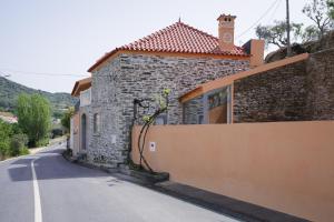 a stone building with a clock tower on a street at Feel Discovery Casa da Aldeia in Mós