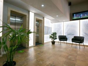 an office lobby with two chairs and a tv at ibis Styles Dunarea Galati in Galaţi