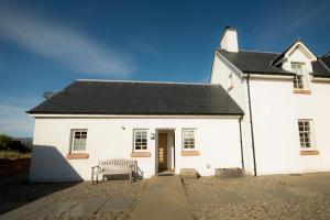 a white building with a bench in front of it at Farmhouse with Loch Views in Gartocharn