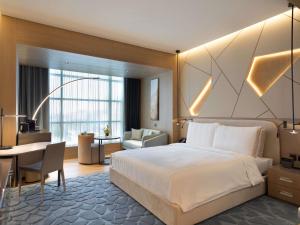 ein Hotelzimmer mit Bett und Schreibtisch in der Unterkunft La Cigale Hotel Managed by Accor in Doha