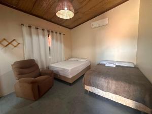 a room with a bed and a chair in a room at Casa do Bento - Lençóis Maranheses in Santo Amaro