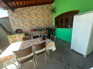 a dining room with a table and chairs and a refrigerator at Casa do Bento - Lençóis Maranheses in Santo Amaro