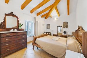 a bedroom with a bed and a dresser and a mirror at Rosa Di Mare Guest House in Finale Ligure