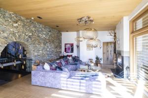 ein Wohnzimmer mit einem blauen Sofa und einer Steinwand in der Unterkunft Chasa Sentima in Sent