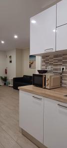 a kitchen with white cabinets and a living room at Villa Ti Neves - Peniche Beach Residence in Peniche