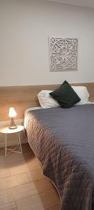 a bedroom with a bed and a table with a lamp at Villa Ti Neves - Peniche Beach Residence in Peniche
