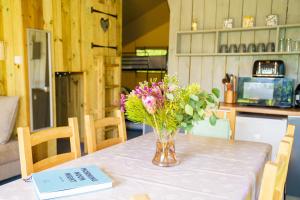 a vase of flowers sitting on top of a table at The Firs Glamping in Welland