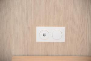 a white light switch on a wooden wall at FastHotel Thionville in Thionville