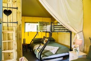 a bedroom with two bunk beds in a tent at The Firs Glamping in Welland