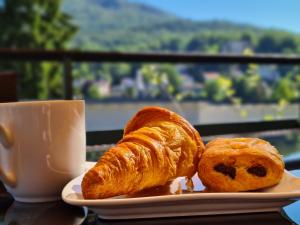 a plate with two croissants and a cup of coffee at Family Suites & Parking in Baden-Baden