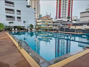a large swimming pool in a city with tall buildings at Cozy 1br walk to BTS and Airport Rail Link Close to Malls T in Bangkok