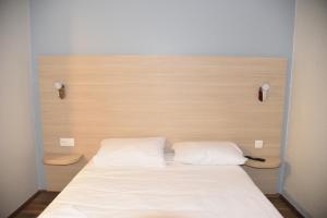 a bed with two white pillows in a room at FastHotel Thionville in Thionville