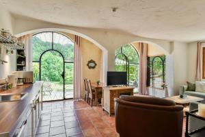 a kitchen with arched windows and a living room at Font Neuve in Souillac
