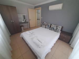 a bedroom with a large bed with white sheets at Karya Apartments in Koycegiz