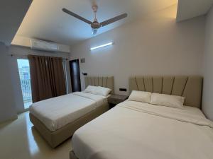 a bedroom with two beds and a ceiling fan at Hotel Moon Light in Dhaka