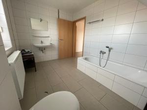 a bathroom with a tub and a toilet and a sink at Am Wangermeer 14 in Wangerland +15 photos