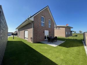 a brick house with a table and chairs in a yard at Wangerbrise in Wangerland