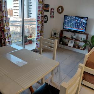 a living room with a dining table and a tv at departamento temporal 38 y 13 con cochera para AUTO in La Plata
