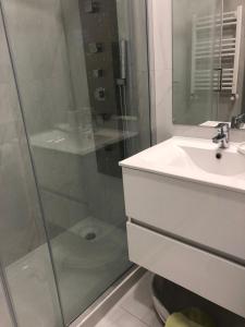 a bathroom with a glass shower and a sink at T1 Figueira da Foz in Buarcos