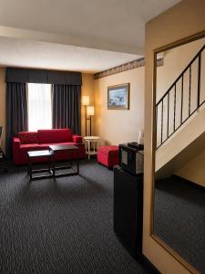 a hotel room with a red couch and a living room at Ramada by Wyndham Trenton in Trenton +21 photos