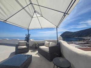 a patio with two chairs and an umbrella at Hotel Odissea in Canneto
