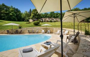 a swimming pool with chairs and umbrellas next to a pool at Font Neuve in Souillac