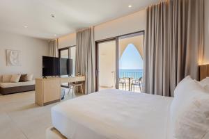 a bedroom with a bed and a desk with a television at Ulin Boutique Hotel in Borsh +69 photos