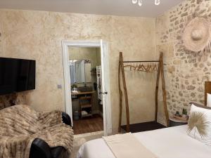 a bedroom with a bed and a television and a bathroom at Le Relais de la Chouette in Berson