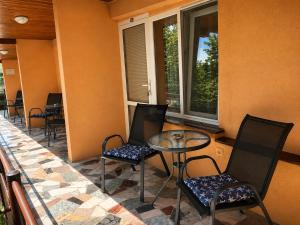 a balcony with a table and chairs and windows at Family Hotel Yulian in Kranevo
