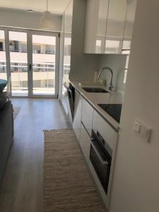 a kitchen with a sink and a counter top at T1 Figueira da Foz in Buarcos