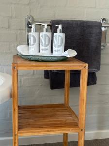 a table with three bottles of toothbrushes on it at Matopos Loft in Stilbaai-Wes +10 photos