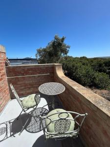 a patio with a table and two chairs and a table and chairs at Matopos Loft in Stilbaai-Wes