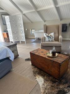 a room with a bed and a couch and a coffee table at Matopos Loft in Stilbaai-Wes