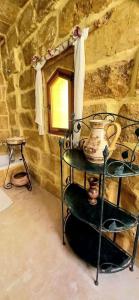 a shelf with a vase on it in a stone room at Mithna farmhouse in Għarb