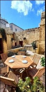 a wooden table with chairs and a tableasteryasteryasteryasteryasteryasteryasteryastery at Mithna farmhouse in Għarb