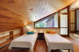 two beds in a room with a large window at Casa Centomila Volte Benvenuti in Tigliole +31 photos