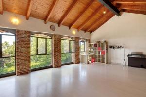 an empty room with windows and a brick wall at Casa Centomila Volte Benvenuti in Tigliole