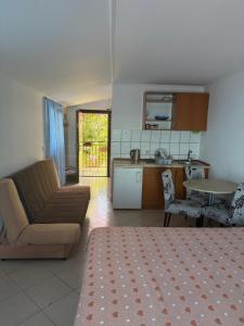 a living room and kitchen with a couch and a table at Villa Palma in Prijevor