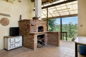 a brick fireplace in a living room with a tv at Casa Centomila Volte Benvenuti in Tigliole