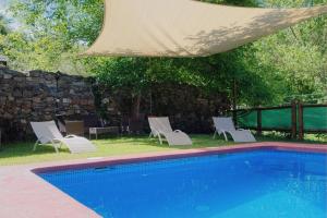 a group of white chairs and a swimming pool at Ribera del Cantero in Ponferrada