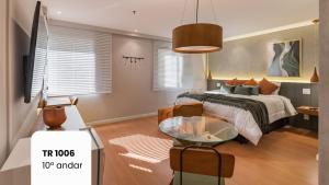 a bedroom with a bed and a glass table at Cyclinn Faria Lima Itaim in São Paulo +4 photos