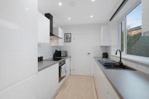 a white kitchen with a sink and a window at Sunderland 3BR Retreat Sleeps 6 by Stay With Us in Pallion