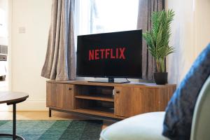 a television on a wooden entertainment center in a living room at Sunderland 3BR Retreat Sleeps 6 by Stay With Us in Pallion
