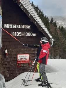 a person on skis in front of a building at Kopffrei auf 1000 m Wohnung 2 in Feldberg