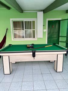 a pool table in a room with a green at Casa Verde Mar com Sinuca in Barra Velha
