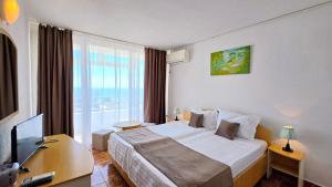 ein Hotelzimmer mit Bett und Fernseher in der Unterkunft Hotel Cerna in Saturn